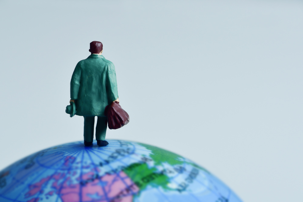 miniatura człowieka stojąca na globusie